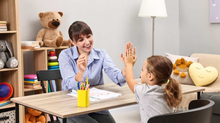 A child working with an ABA therapist in a cozy setting with toys around, showing everyday support related to level 1 autism