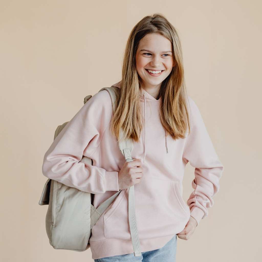A young student with a backpack stands confidently, symbolizing college students with autism finding comfort and support in their academic environment