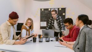 Group of young adults collaborating in a meeting room, illustrating autism in adults navigating work, communication, and daily life.