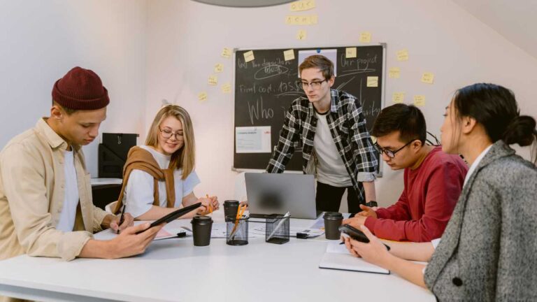 Group of young adults collaborating in a meeting room, illustrating autism in adults navigating work, communication, and daily life.