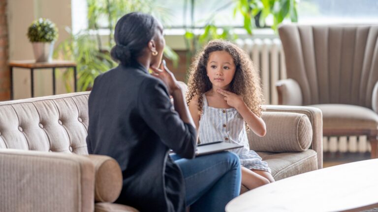 Care professional teaches in-home ABA therapy to young girl