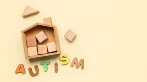 Wooden house with blocks and colorful letters spelling autism, symbolizing types of autism and levels of support