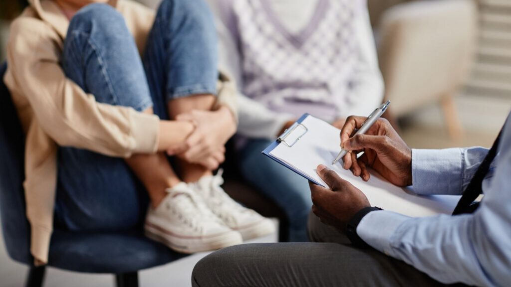 What Is the Y-BOCS Scale? Understanding Autism and OCD Clinician taking notes during an OCD assessment with a child and parent
