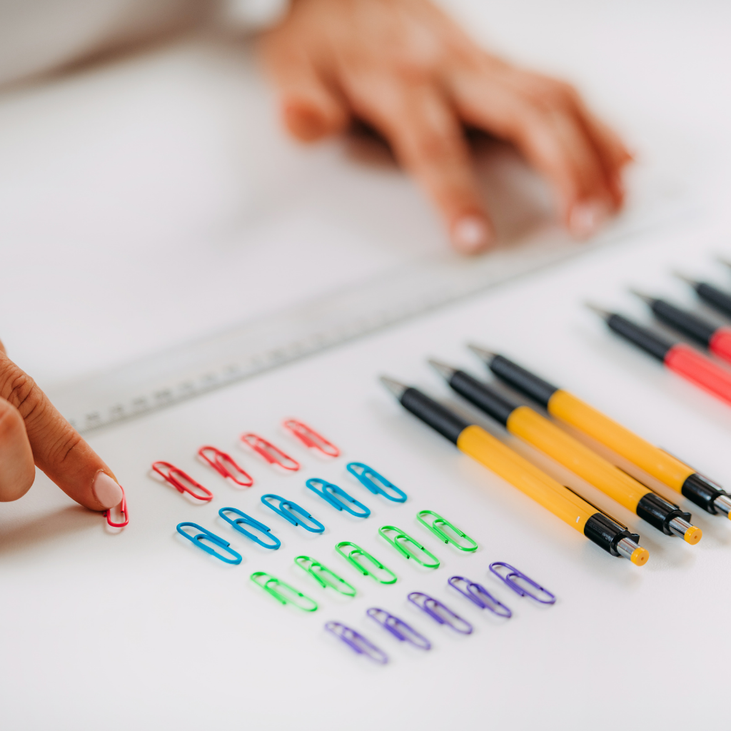 Hands arranging colored paper clips during a structured activity