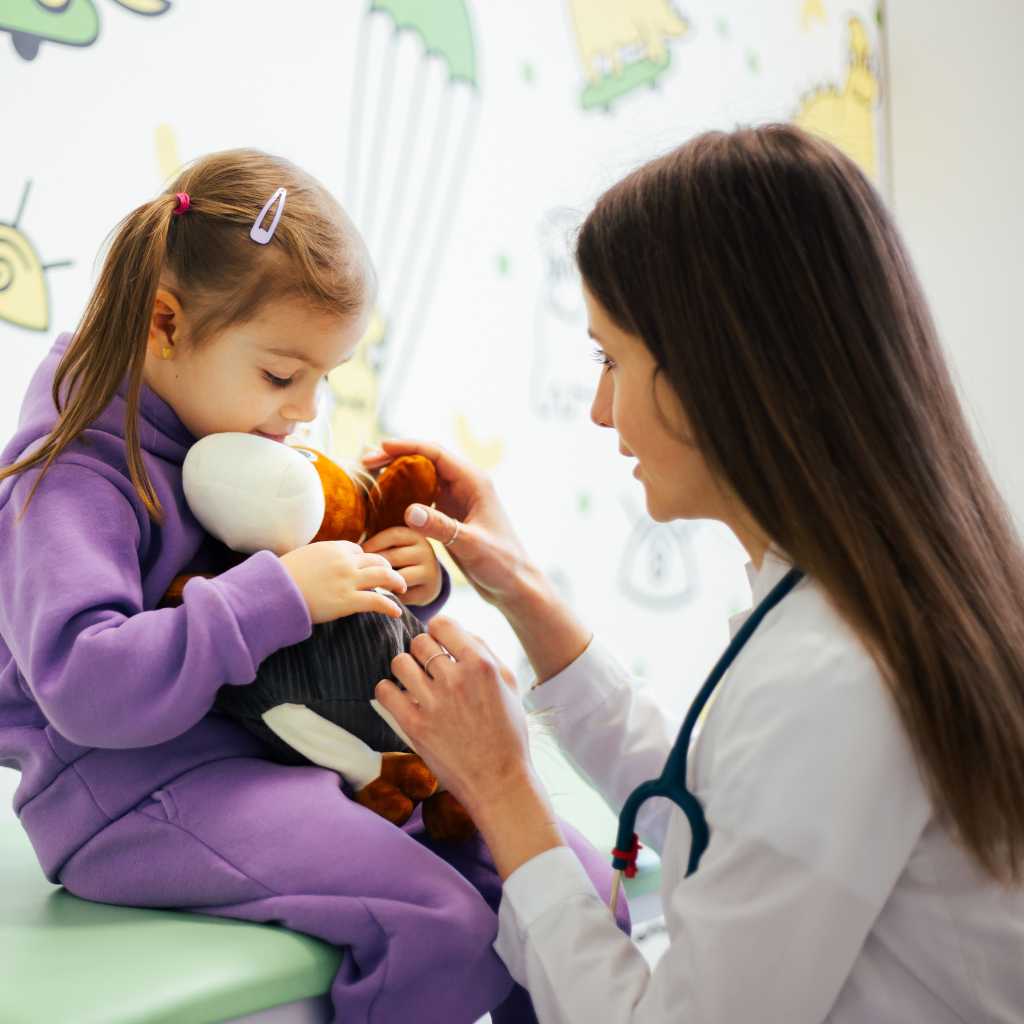 Doctor supporting a young child during an autism evaluation report review