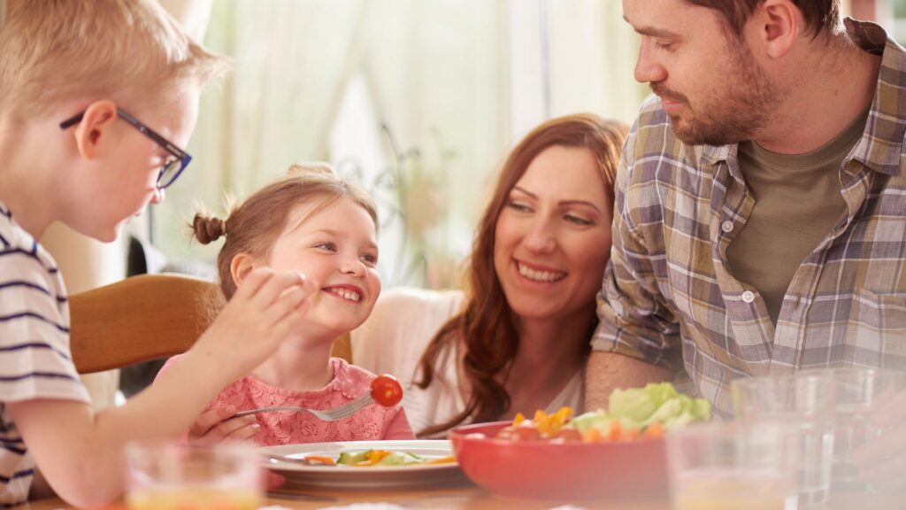 Raising a Child With Autism: Navigating Your Family’s Unique Journey Family sharing a meal together at home as part of an autism parenting journey