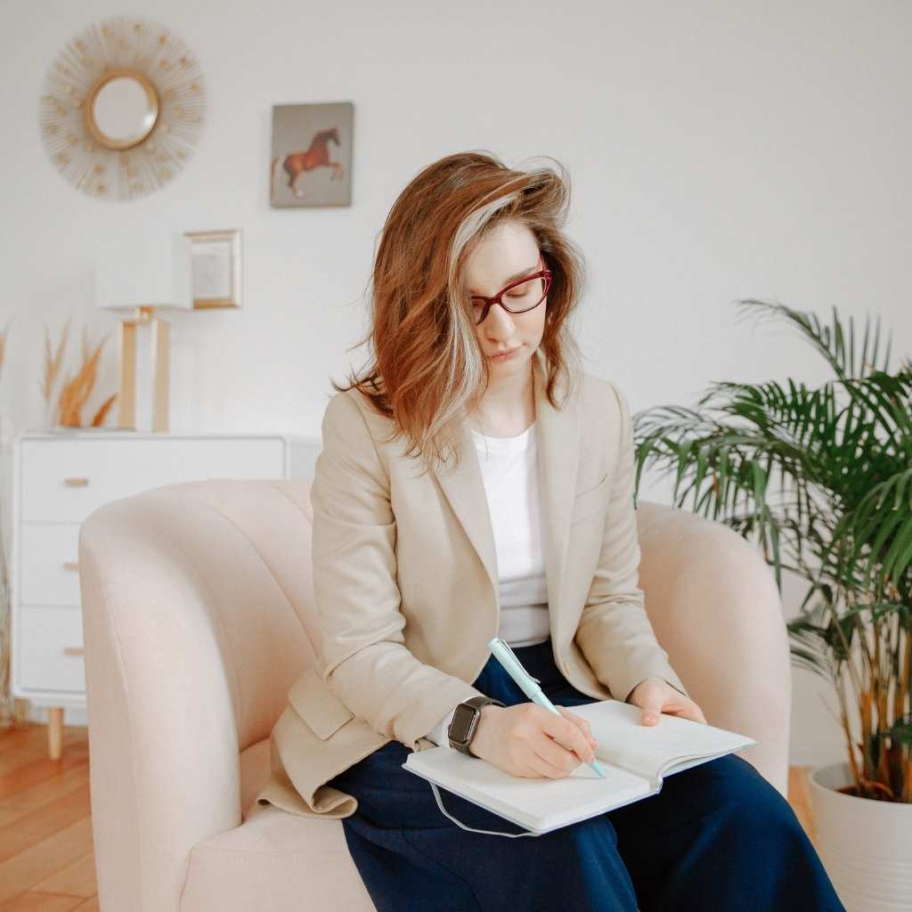 Parent taking notes while reflecting after a child's autism diagnosis