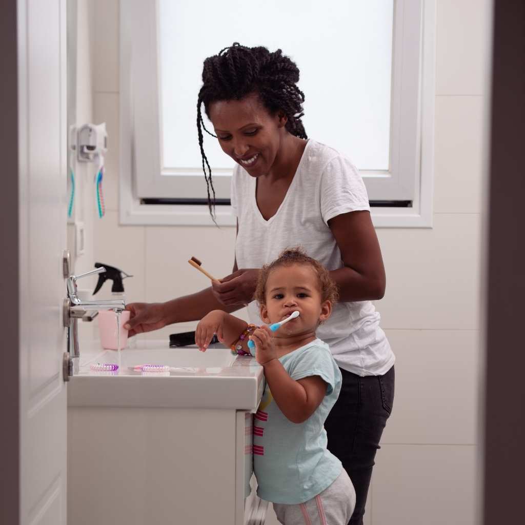 Parent helping a young child with autism practice a daily hygiene routine at home